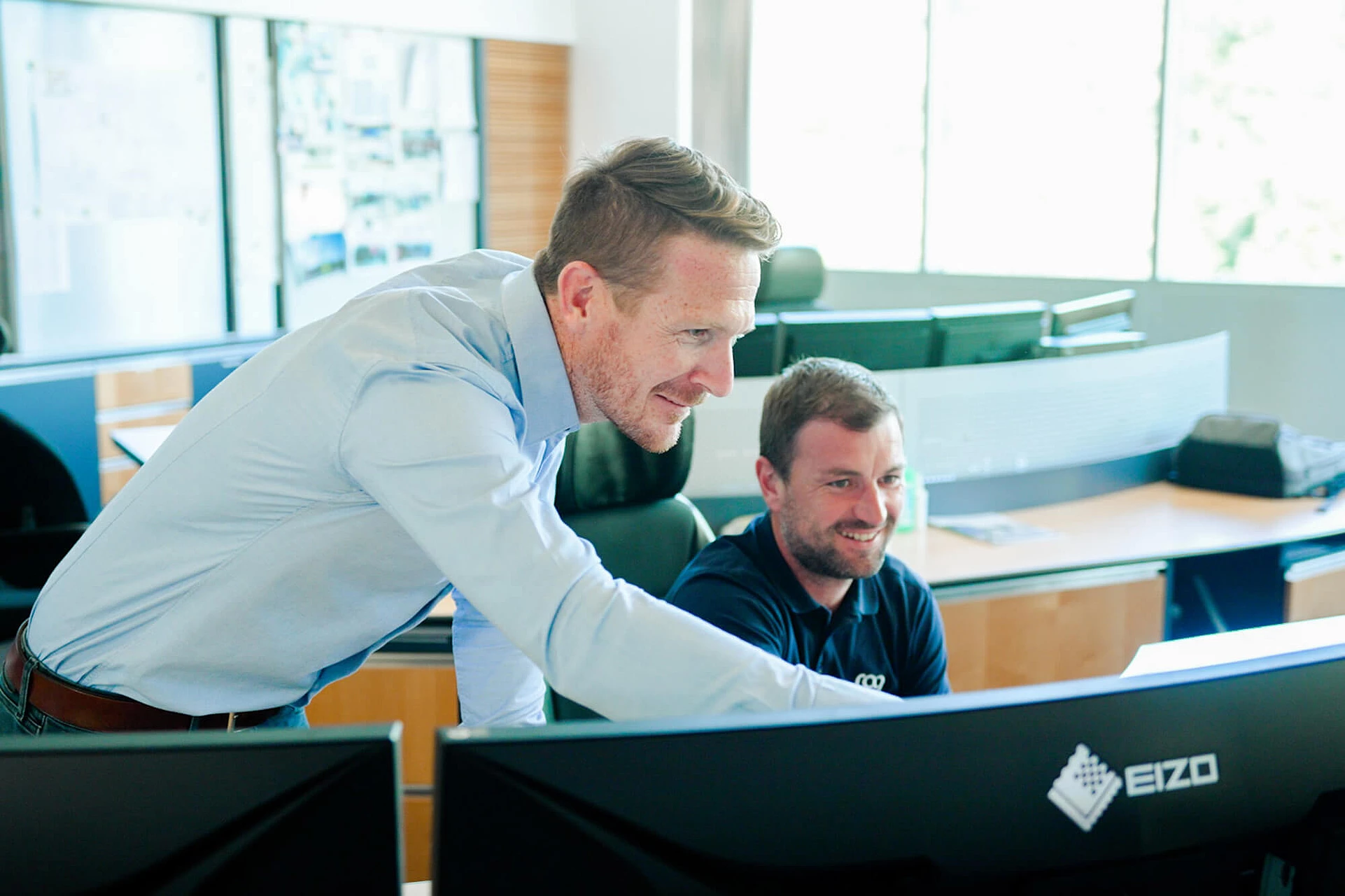 Mitarbeiter schauen auf einen Bildschirm im Büro